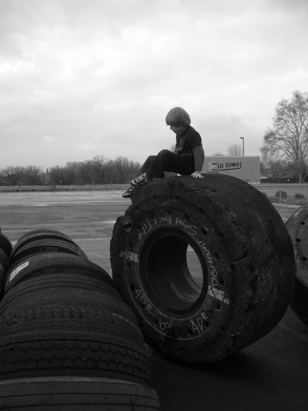 son on giant old tire...