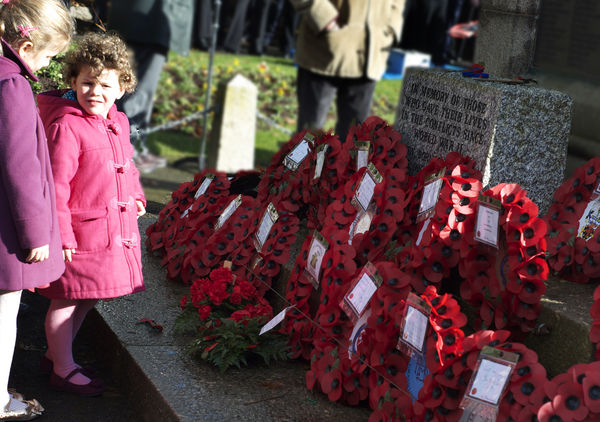 Youngsters looking at the laid wreaths...