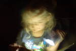 Mirabelle (4 yrs.old) reading by flashlight during...