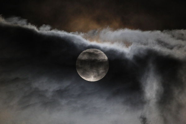 moon behind cloudy sky...