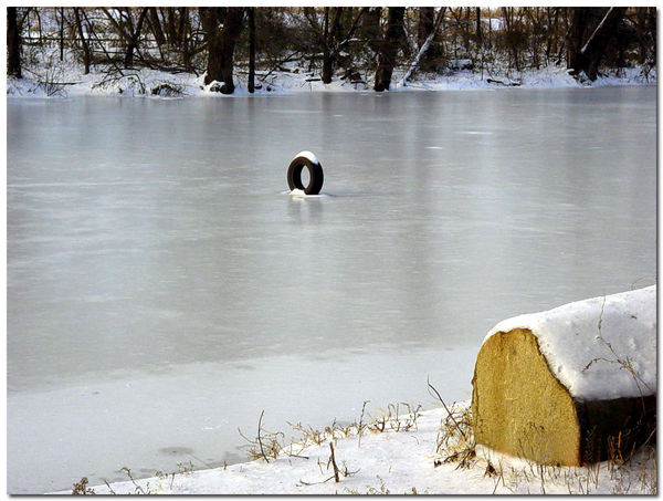 AN AUTOMOBILE TIRE STANDING ON THE ICE OF THE JAME...