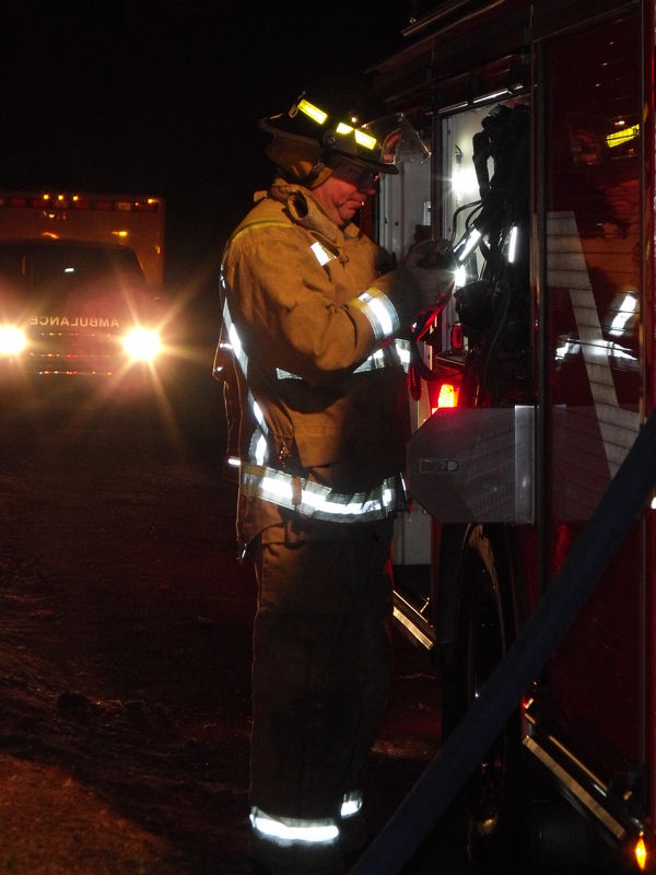 Firefighter/EMT standing still checking equipment ...