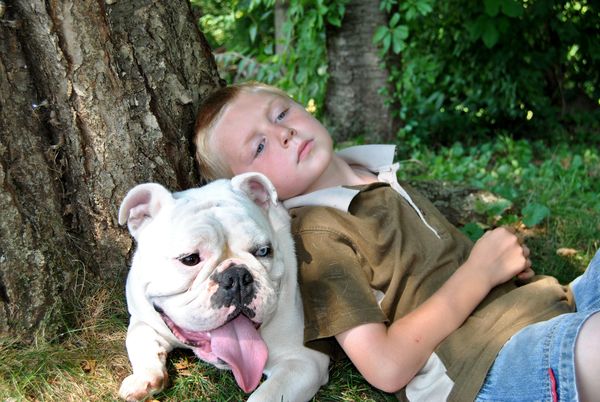Boy and his dog take a break in the shade...