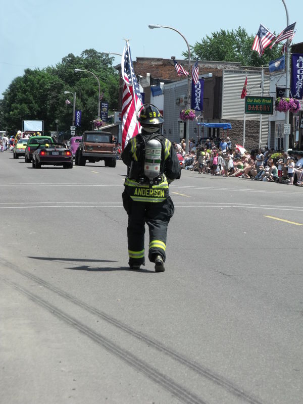 Firefighter Anderson carrying the American Flag in...