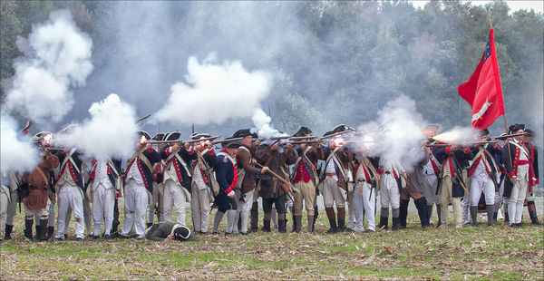 American Patriots fire musket volley...