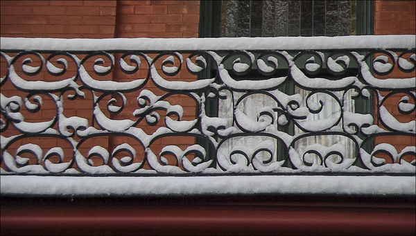 Morning snow on a wrought iron railing...