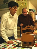 Creating a gingerbread house w/grandson (husband i...