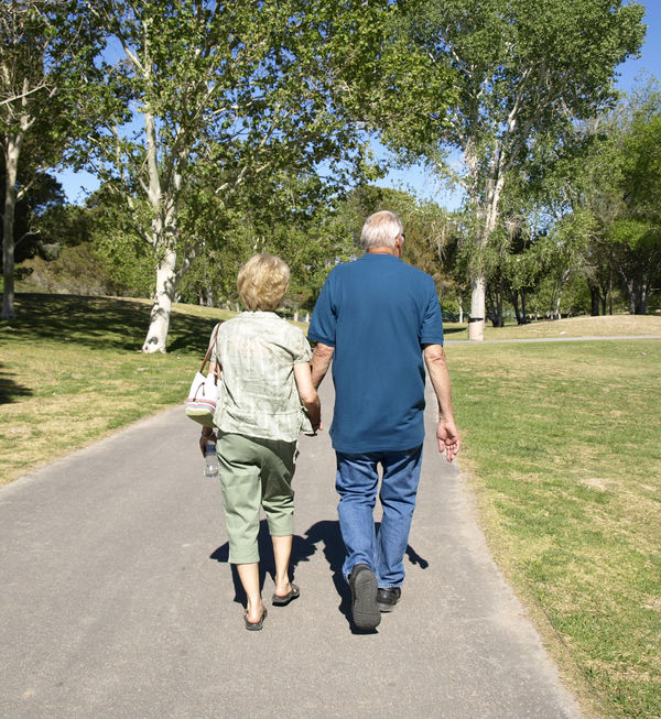 older couple walking in the park hand in hand...