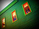 Green Siding on a Building with Red Window Trim...