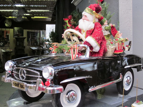 Santa in an antique petal car...