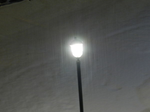 Snow coming down in front of out lamp post...
