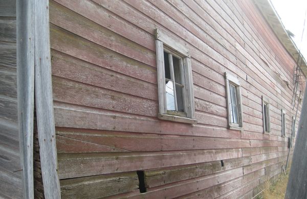 the windows on the side of an old barn that was fa...
