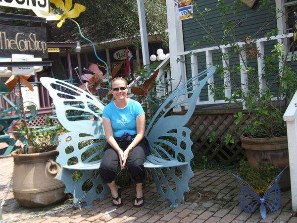 my daughter sitting on a Butterfly bench...