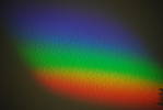 A rainbow refraction on the wall from a cut glass ...