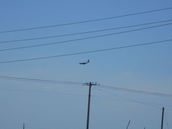A C130 military transport jet flying over...