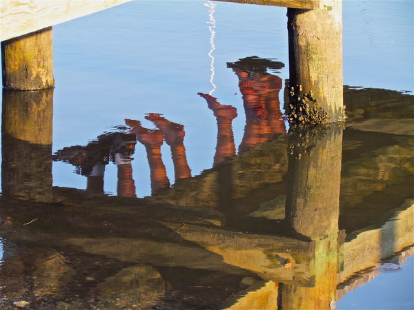 Reflection- dangling feet off the pier....