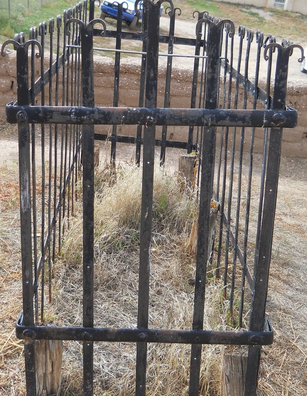 L shaped iron fence around old grave...