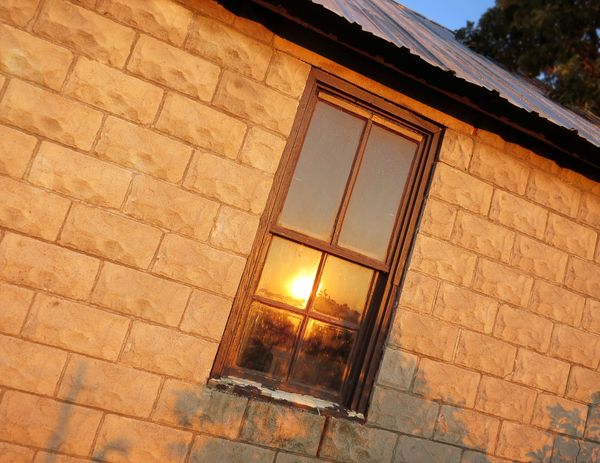 Sunrise shining on an old farmhouse window...