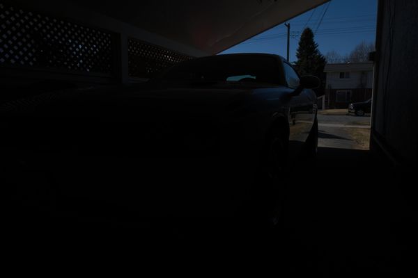 Car in carport.  Focus and meter on front headligh...