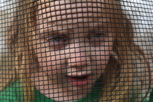 3 year old mugging camera through trampoline mesh...
