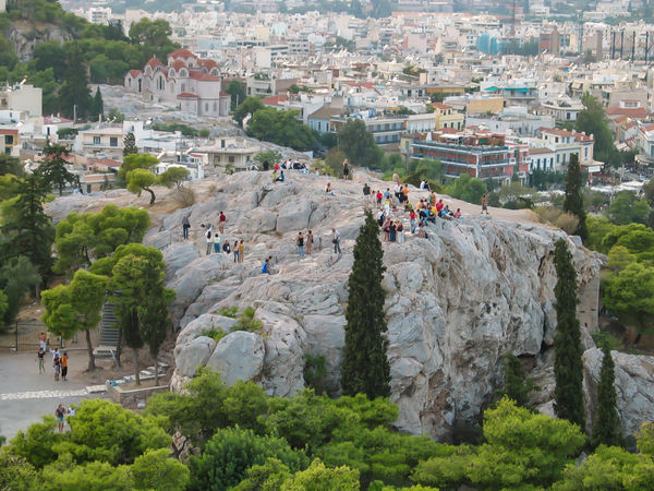 People climbing on rocks near the Acropolis in Gre...