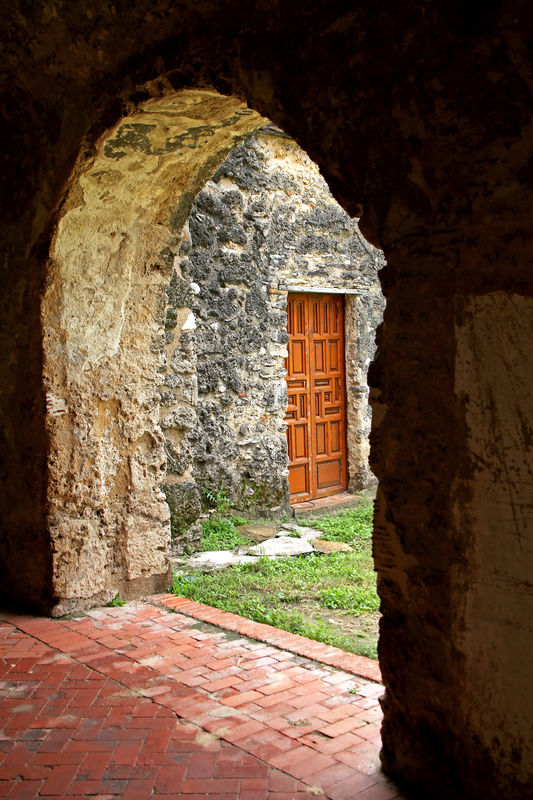 Looking through an arched opening at a doorway at ...