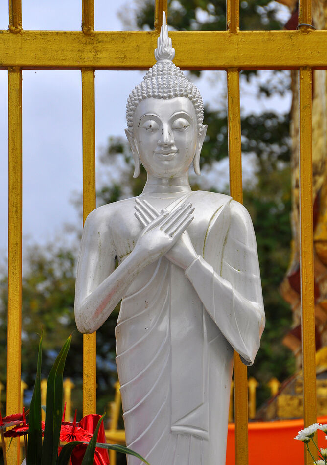 5 - Standing white Buddha with hands folded at the...