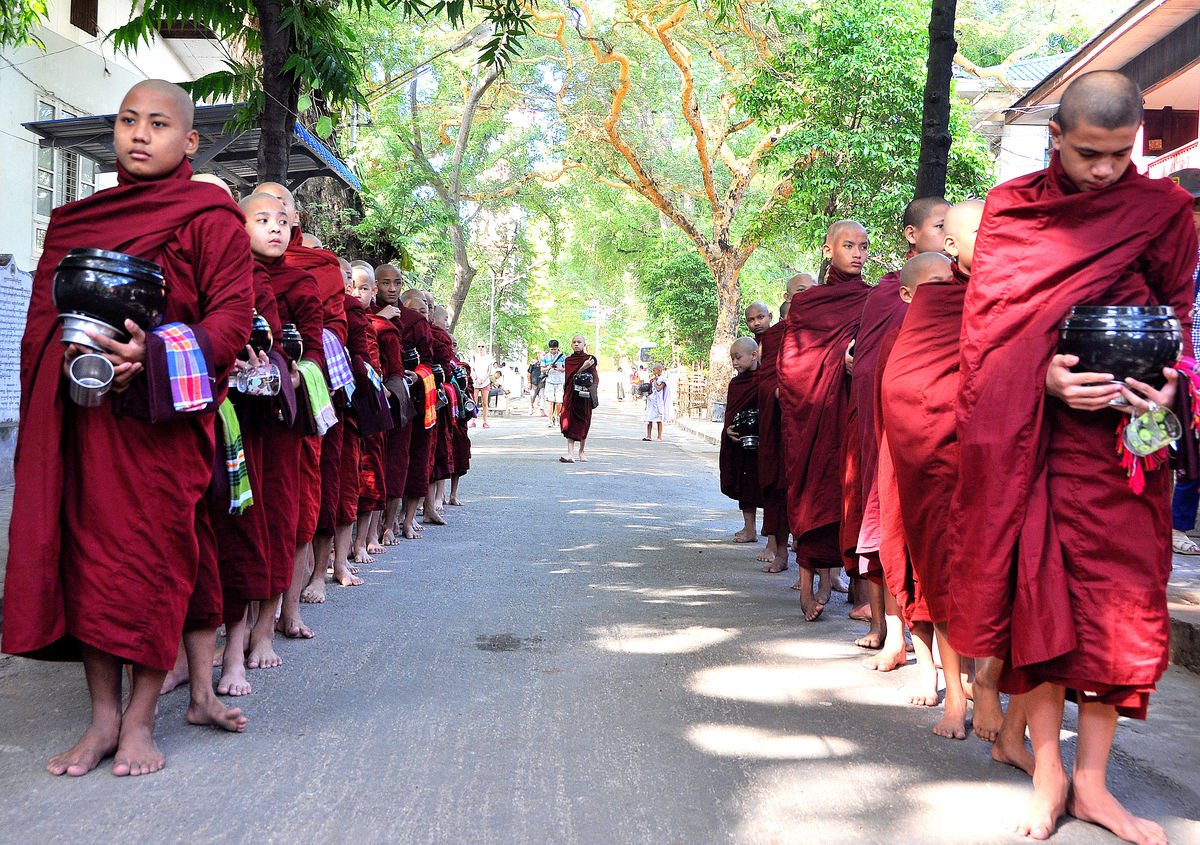 1 - Barefoot monks lining up for lunch, each one h...