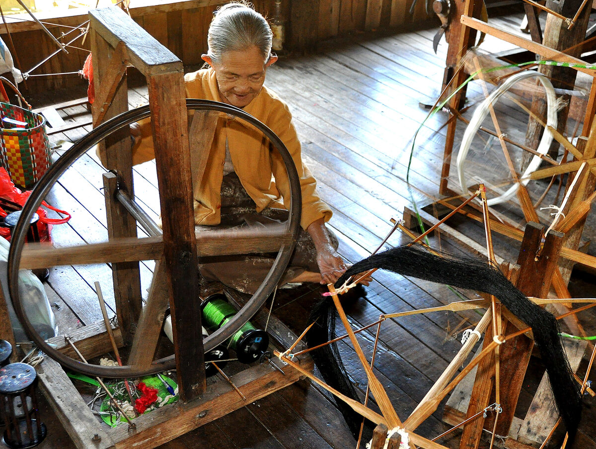 3 - Old woman working at an ancient contraption...