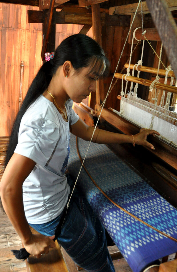 5 - Another young woman working at a loom...
