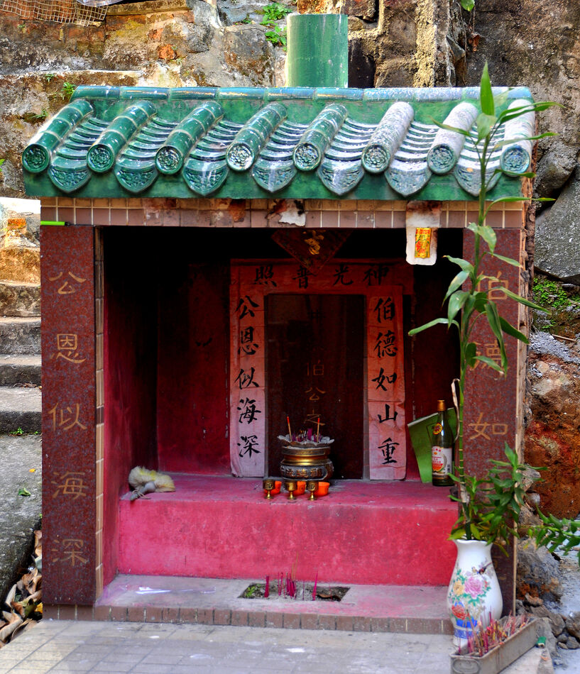 6 - Small streetside shrine with incense sticks...