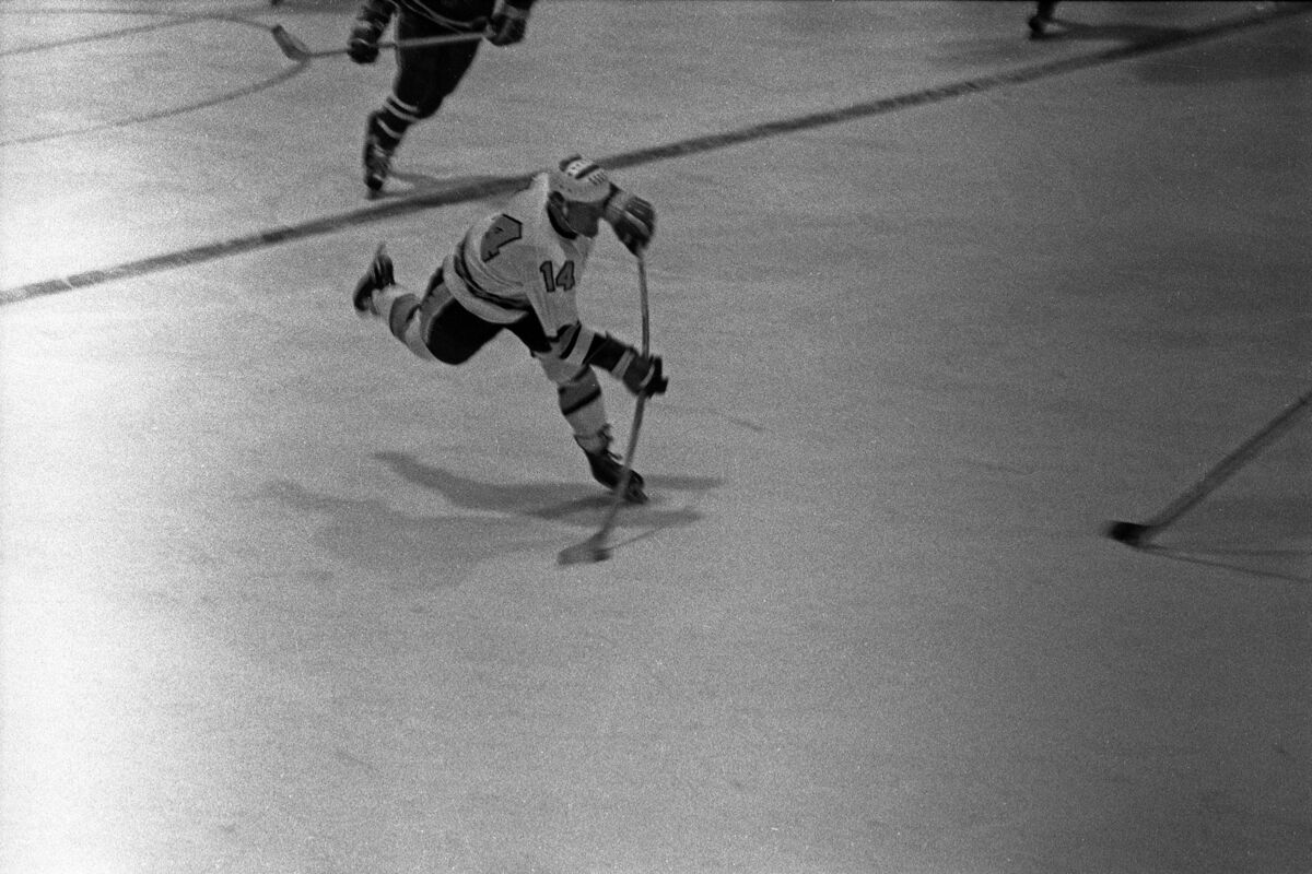 A college hockey player making a slap shot during ...