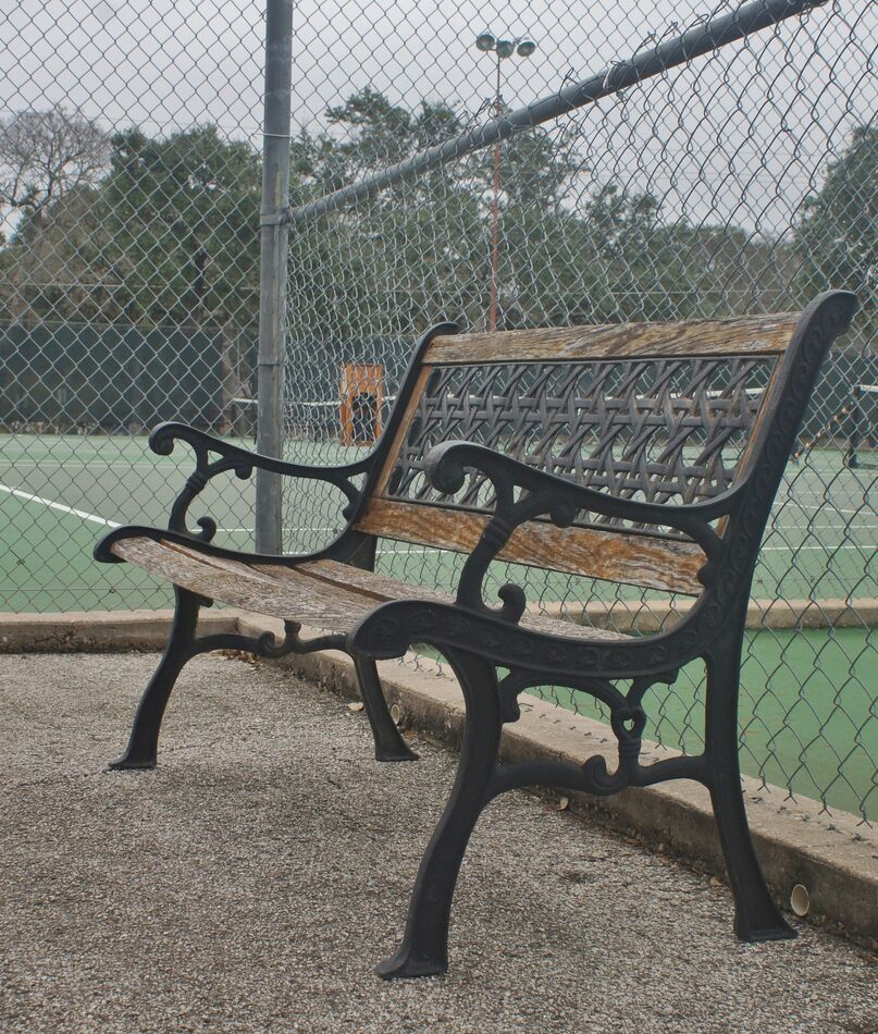 Frames and back on this bench near a tennis court ...