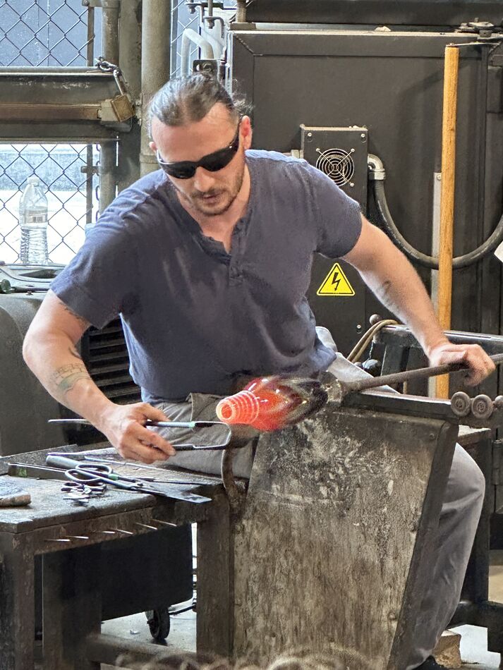 A Master glass blower creating a vase....