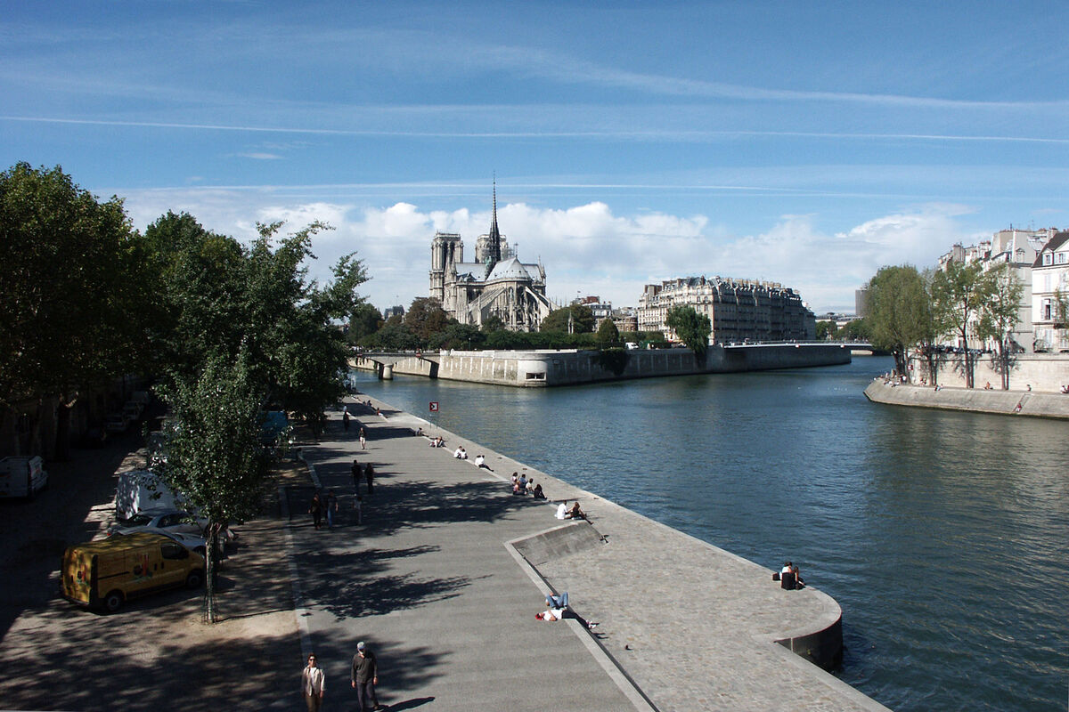 A walkway along the Seine River toward Notre-Dame ...