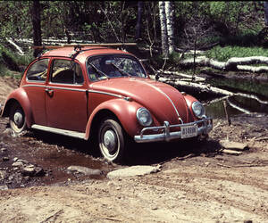 Automobile - a VW Beetle driving thru a stream nea...