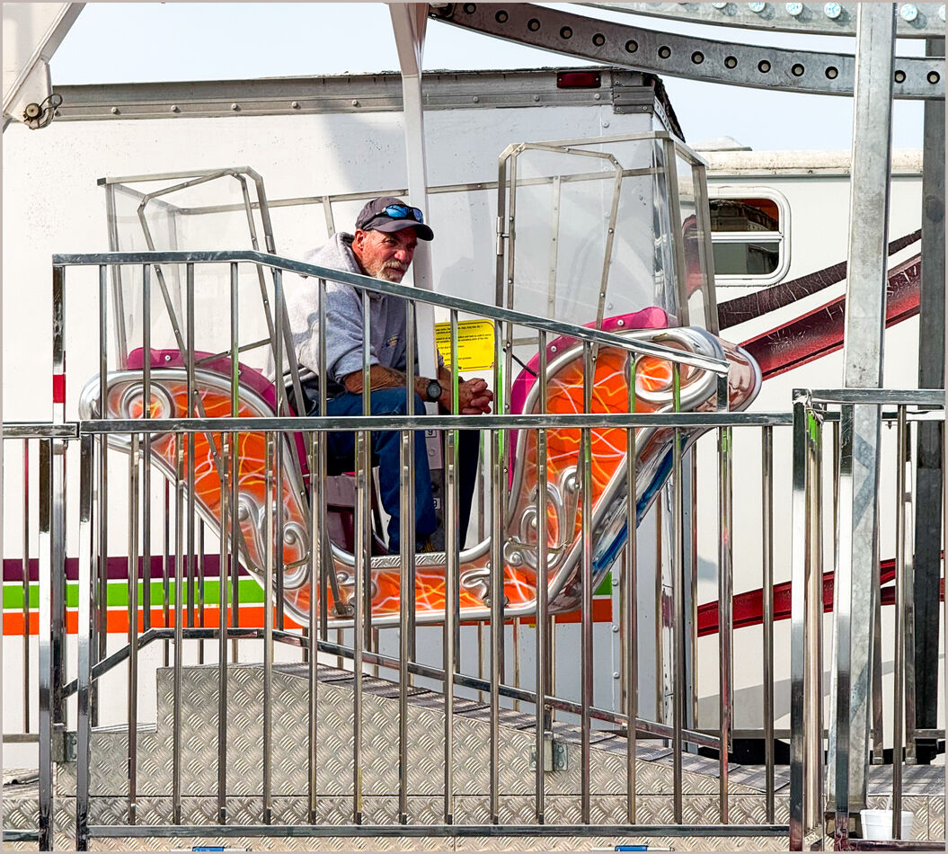 Waiting on a Rider: Amusement ride operator at the Tipton Pork Festival ...